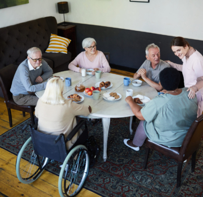 High angle view at diverse group of senior people enjoying breakfast at dining table in nursing home, copy space