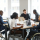 Portrait of successful businesswoman using wheelchair while speaking to employee in meeting, copy space